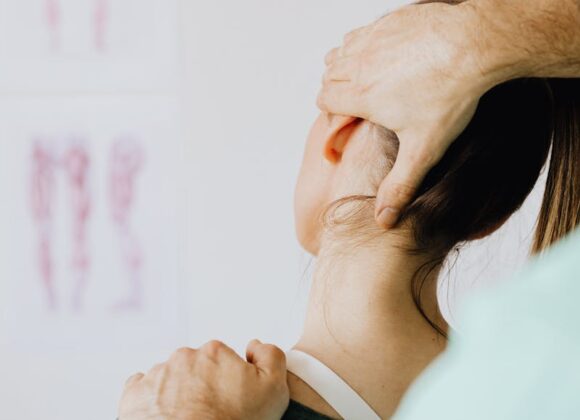 Czym jest fizjoterapia i jak może zmienić twoje życie? A female patient receives a chiropractic neck adjustment in a medical office for pain relief.